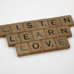 brown wooden blocks on white surface: listen, learn, love (Zuhören, Lernen, Lieben)